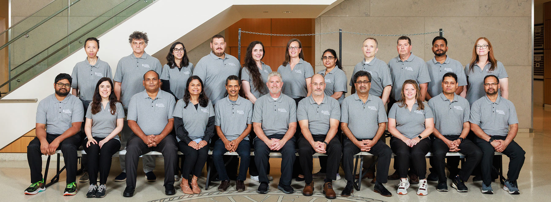 Group portrait of members of the Department of Cell and Molecular Biology inside the School of Medicine lobby. There is a stairase behind them.